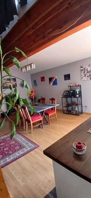 Een eethoek met een houten tafel, stoelen en een plant.