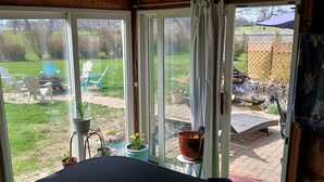 Et værelse med udsigt til en baghave, en patio og en træterrasse.