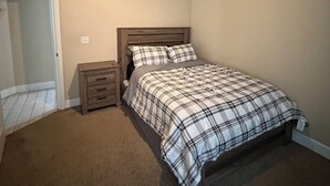 A bedroom with a bed, a nightstand, a ceiling fan, and a door. - Spacious 2BR 2BA Near FSU, FAMU & Downtown (Tallahassee)