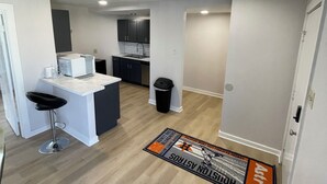 Una cocina moderna con armarios blancos, encimera negra y pileta de acero inoxidable.