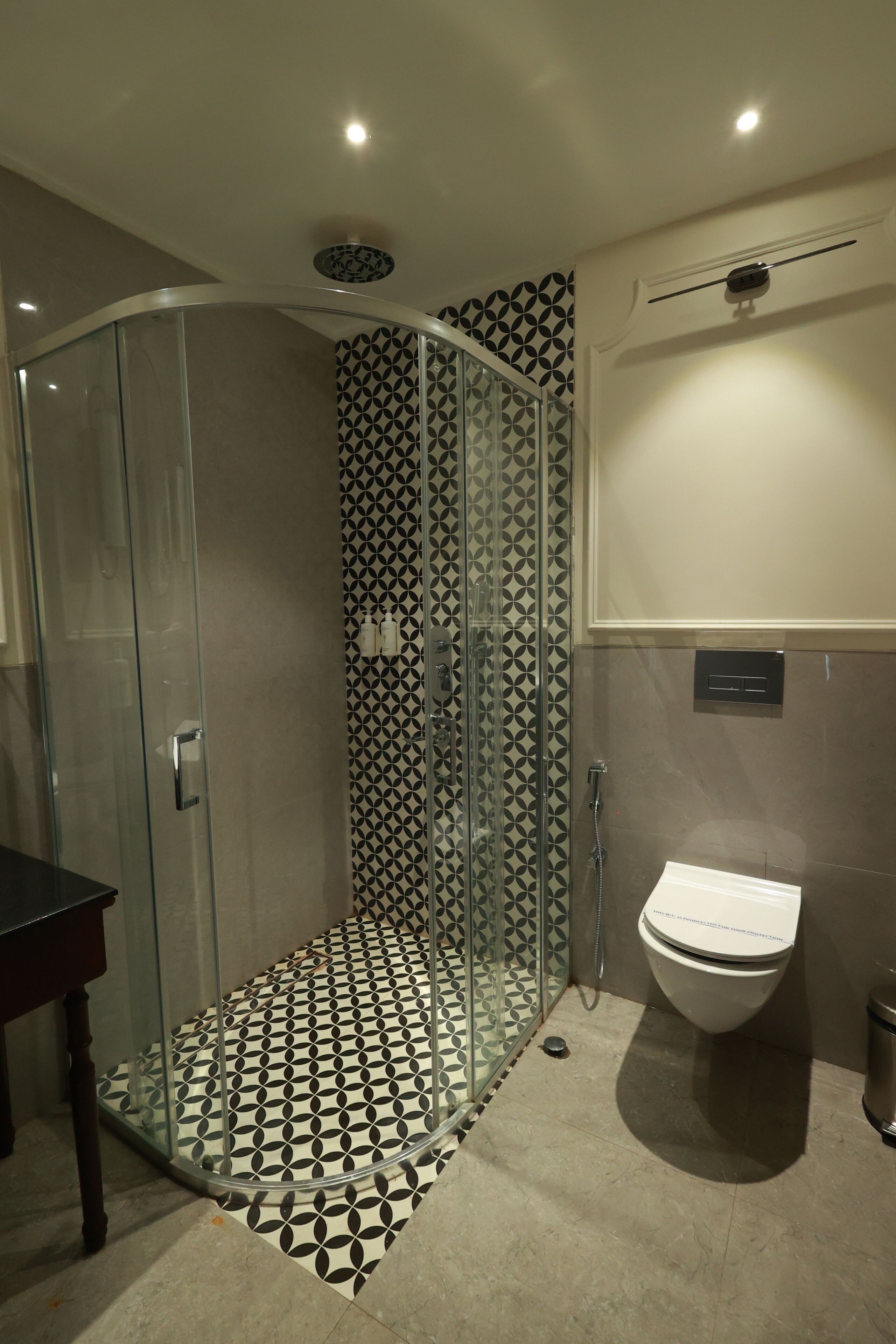 A bathroom with a glass-enclosed shower, a toilet, and a sink.
