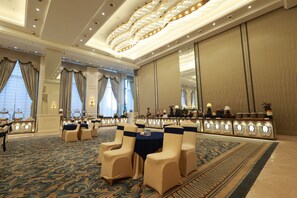 A hotel lobby with a grand chandelier, a reception desk, and a seating area with chairs. - Aurtus (Amravati)