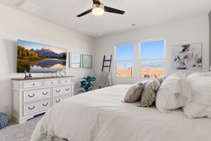 Une chambre à coucher avec un lit, une commode, un tableau, une échelle et une fenêtre donnant sur un beau paysage.