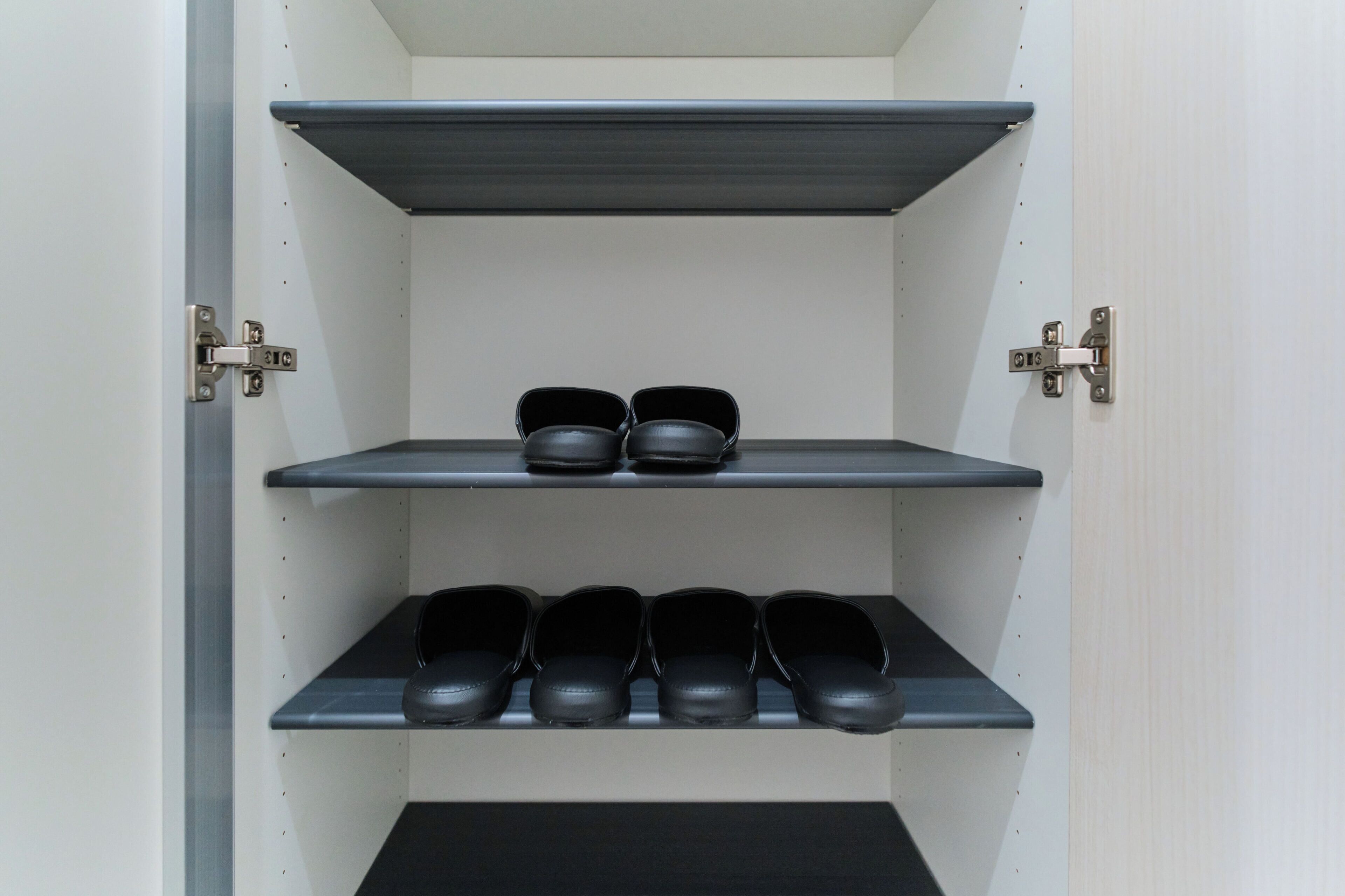 Ein Lagerraum mit Regalen, auf denen schwarze Schuhe stehen.
