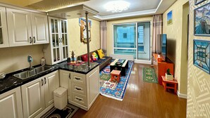 Una cocina moderna con armarios blancos, encimera negra y una ventana.