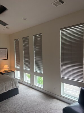 A bedroom with a bed, a nightstand, a lamp, and large windows with blinds. - 3Bed Sports Fan Oasis. 5 mins Astros, 10 mins NRG. (Houston)