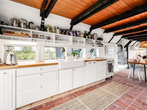 A kitchen with white cabinetry, a wooden countertop, and a brick floor. - "Arendine" - 250m from the sea by Interhome (Ørsted)