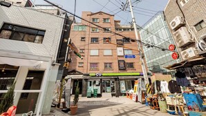 Um edifício comercial com fachada, vários andares e sinalização visível.