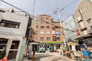 Un edificio comercial con escaparate, varios pisos y señalización visible.