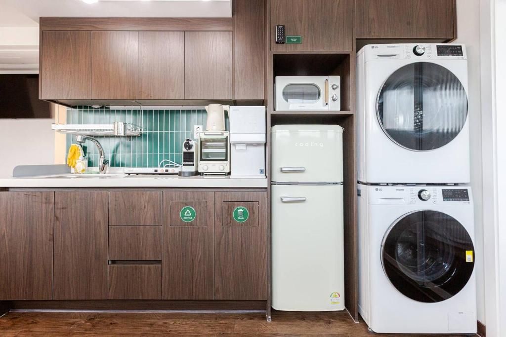 Een kleine keuken met een magnetron, een koffiezetapparaat en een wasmachine.