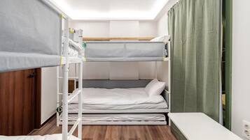 A bunk bed room with a desk and a green curtain.