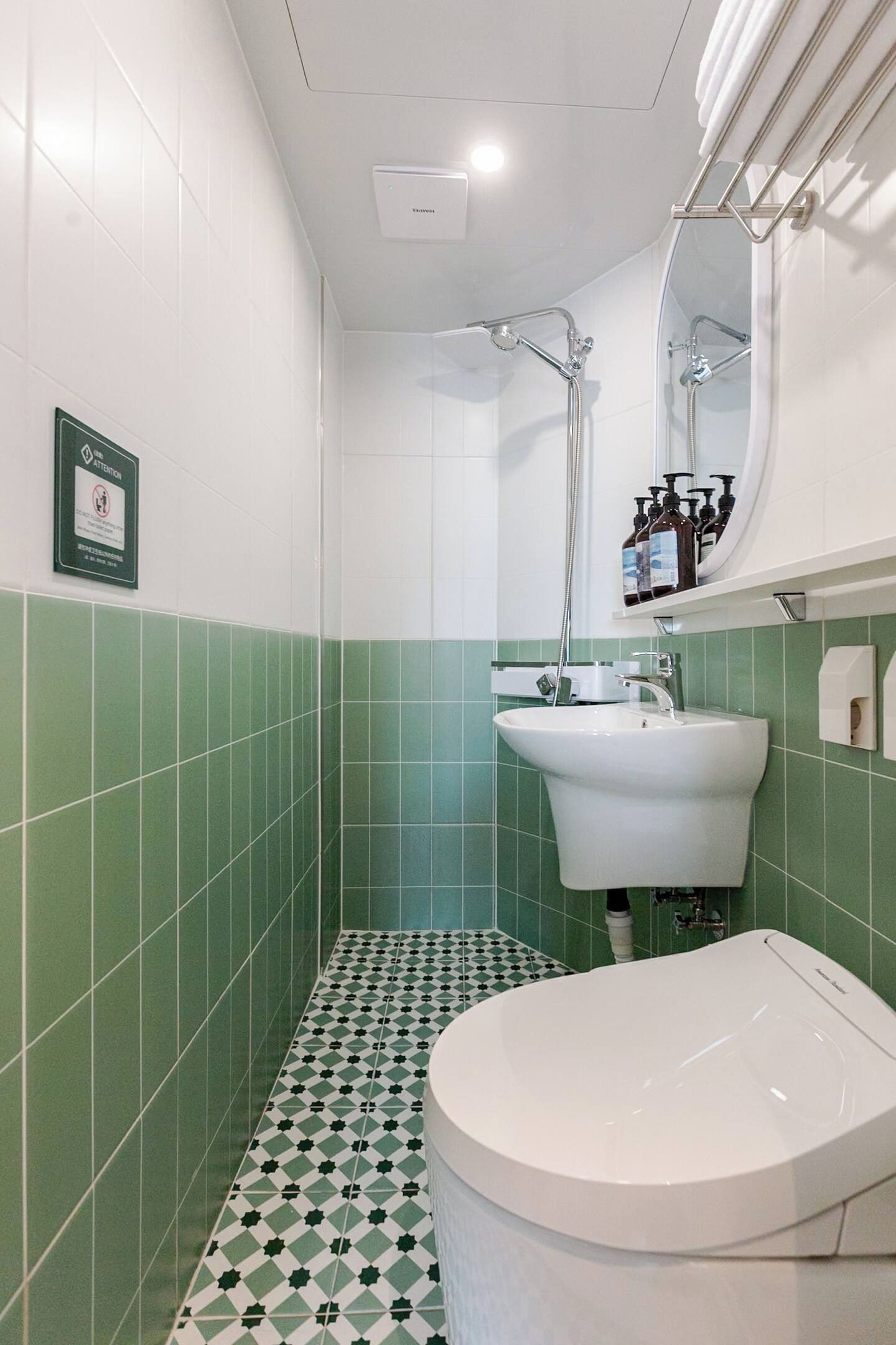 A bathroom with a white sink, a mirror, and a shower.