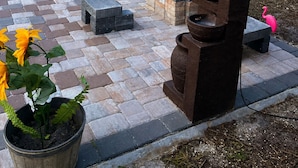 Un patio trasero con zona de juegos, tobogán, hamaca y parrilla.