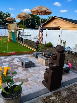 A backyard with a play area, a slide, a hammock, and a barbecue grill. - Minutes Away from the Famous Universal Studios & Other Renowned Attractions (Orlando)
