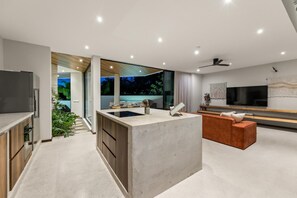 Een moderne woonruimte met keuken, eethoek en entertainmentfaciliteiten.