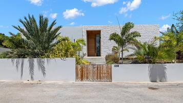 Une maison moderne avec une façade blanche, une porte en bois et une petite fenêtre.