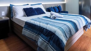 Ein modernes Schlafzimmer mit Bett, Nachttischen und Wandbildern.