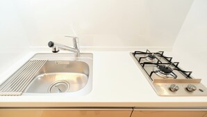 A kitchen with a stainless steel sink and a gas stove. - Sees Kinshicho II (Tokyo)