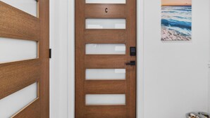 A wooden door with a frosted glass panel, a black handle, and a letter 'C' above the door. - Spacious Waterfront Home_Sleeps 16_7BR_Spacious (Palmetto)
