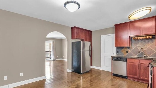 A kitchen with wooden cabinets, a stainless steel refrigerator, and a dishwasher. - Quiet West Plaza Retreat – Spacious Condo in Prime KC Location. (Kansas City)