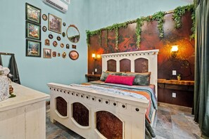 Un lit doté d’une tête de lit décorative, un mur orné de tableaux encadr és et un luminaire fixé au mur.