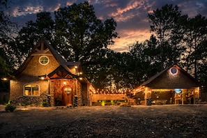Un chalet rustique avec une façade en pierre, une porte en bois et une fenêtre ronde.