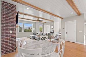 A spacious living area with a fireplace, a dining table, and a seating arrangement.