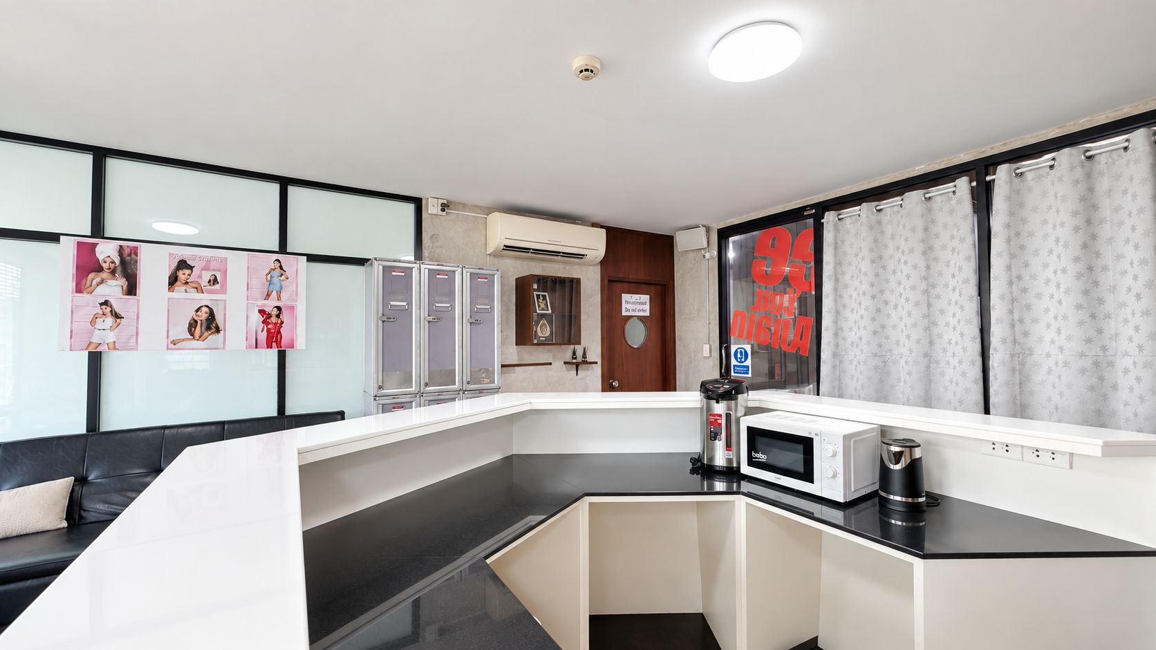 A modern kitchen with a microwave, coffee maker, and cabinets.