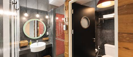 Un baño moderno con un lavabo blanco, un espejo y un inodoro.