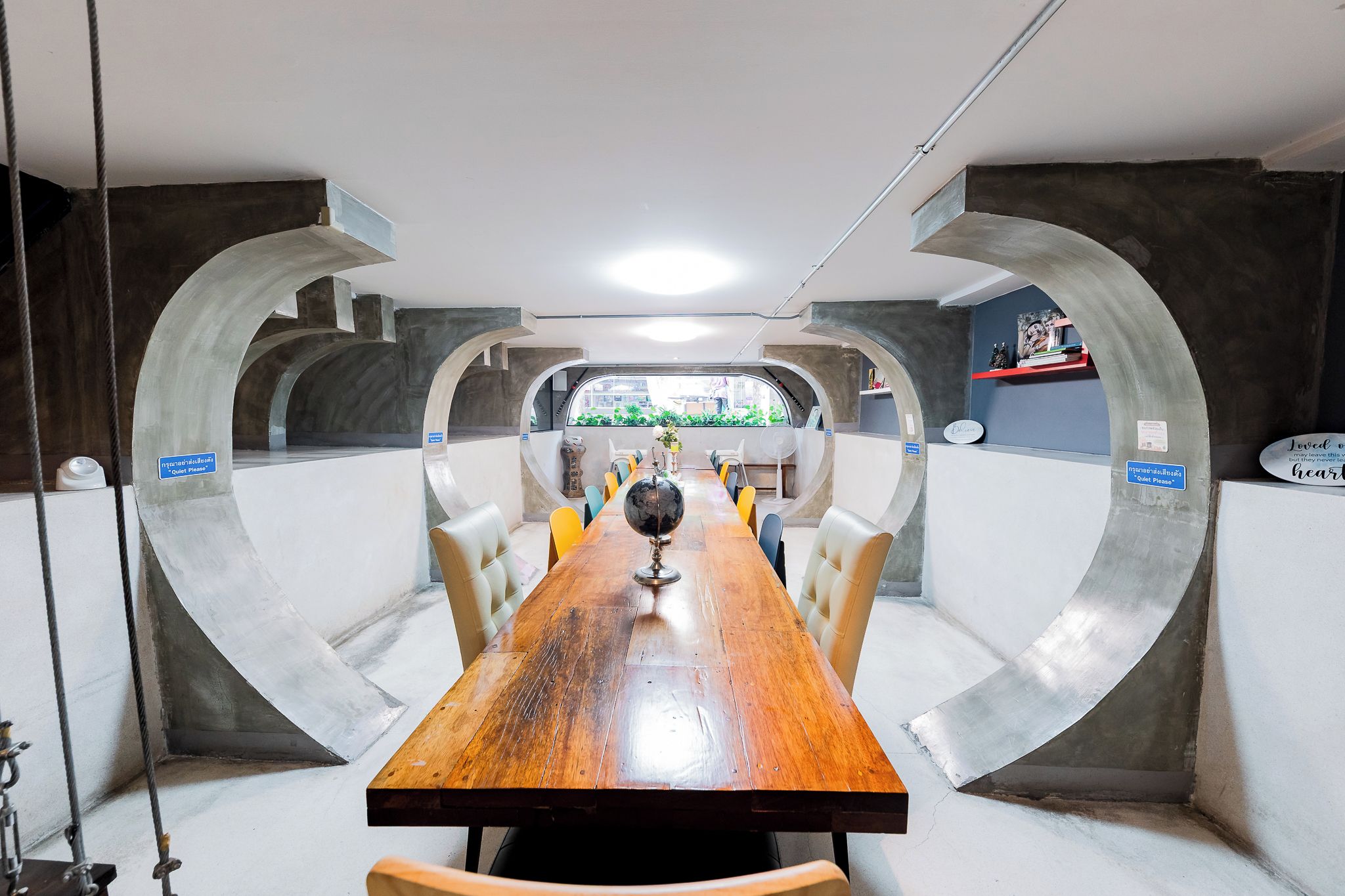 A conference room with a long table, chairs, and a view through a large window.
