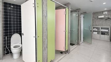 A modern bathroom with a toilet, a shower stall, and a vanity with a mirror.