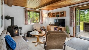 Un salon chaleureux avec une cheminée, un canapé, un téléviseur et un coin repas.