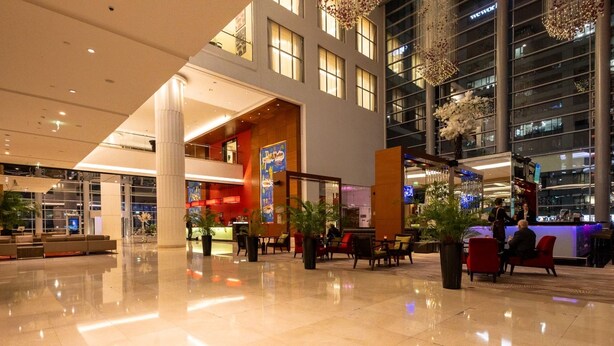 A spacious lobby with a reception desk, seating areas, and a bar. - Platinum Towers by Interhome (Warsaw)