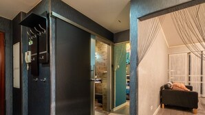 A modern interior with a dark-toned room, a visible phone, a door, and a seating area with a cushion. - Platinum Towers by Interhome (Warsaw)