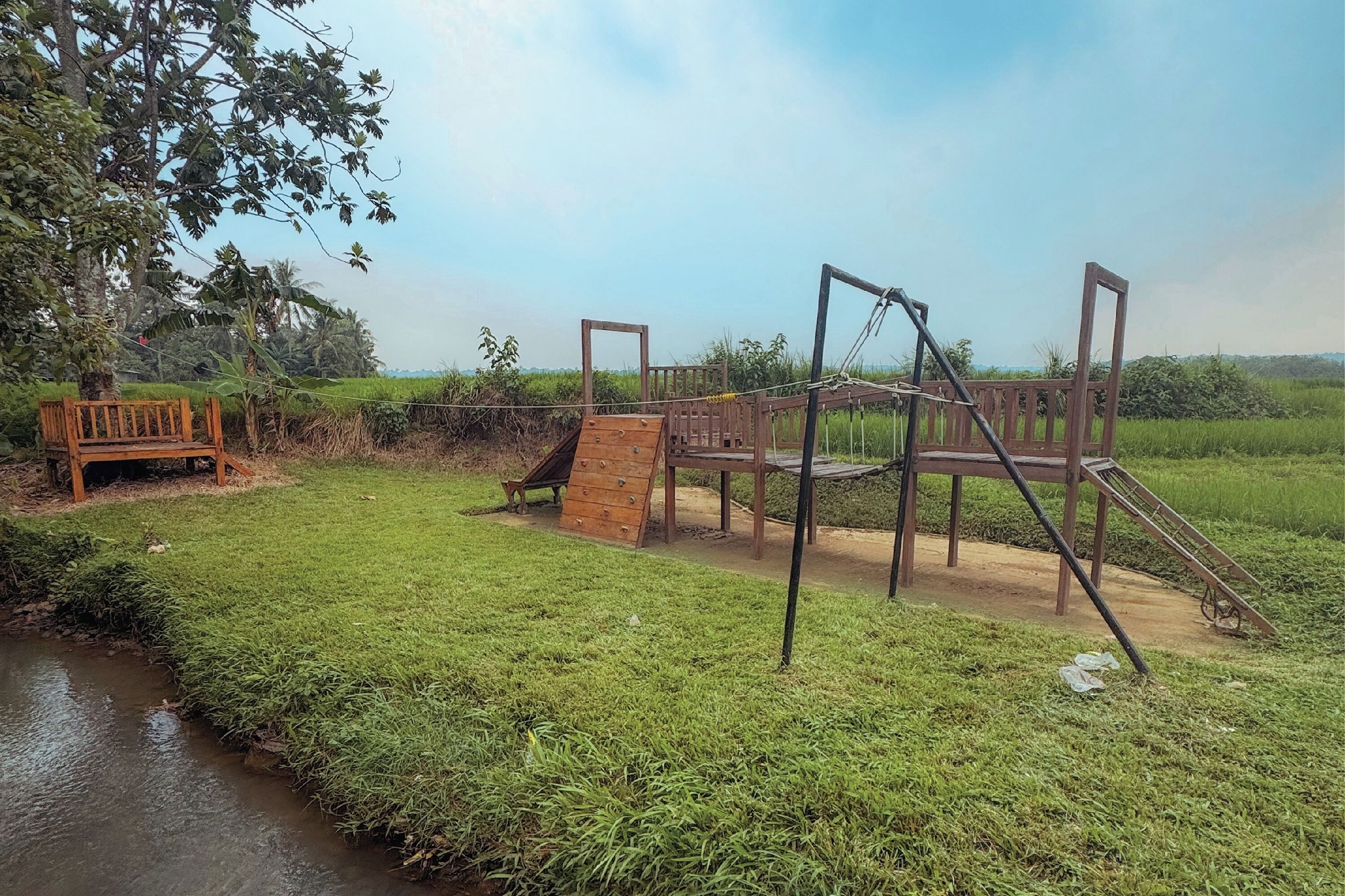 A playground with a wooden slide and climbing structures.
