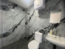 Un baño con inodoro, lavamanos y ducha.