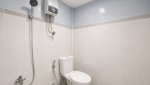 A bathroom with a toilet, a shower, and a water heater. - Nata Hotel Tasikmalaya (Tasikmalaya)