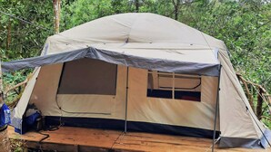 Una carpa con una plataforma elevada, una ventana y una puerta.