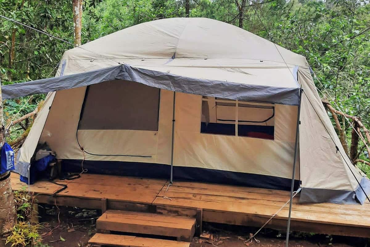 A tent with a raised platform, a window, and a door.