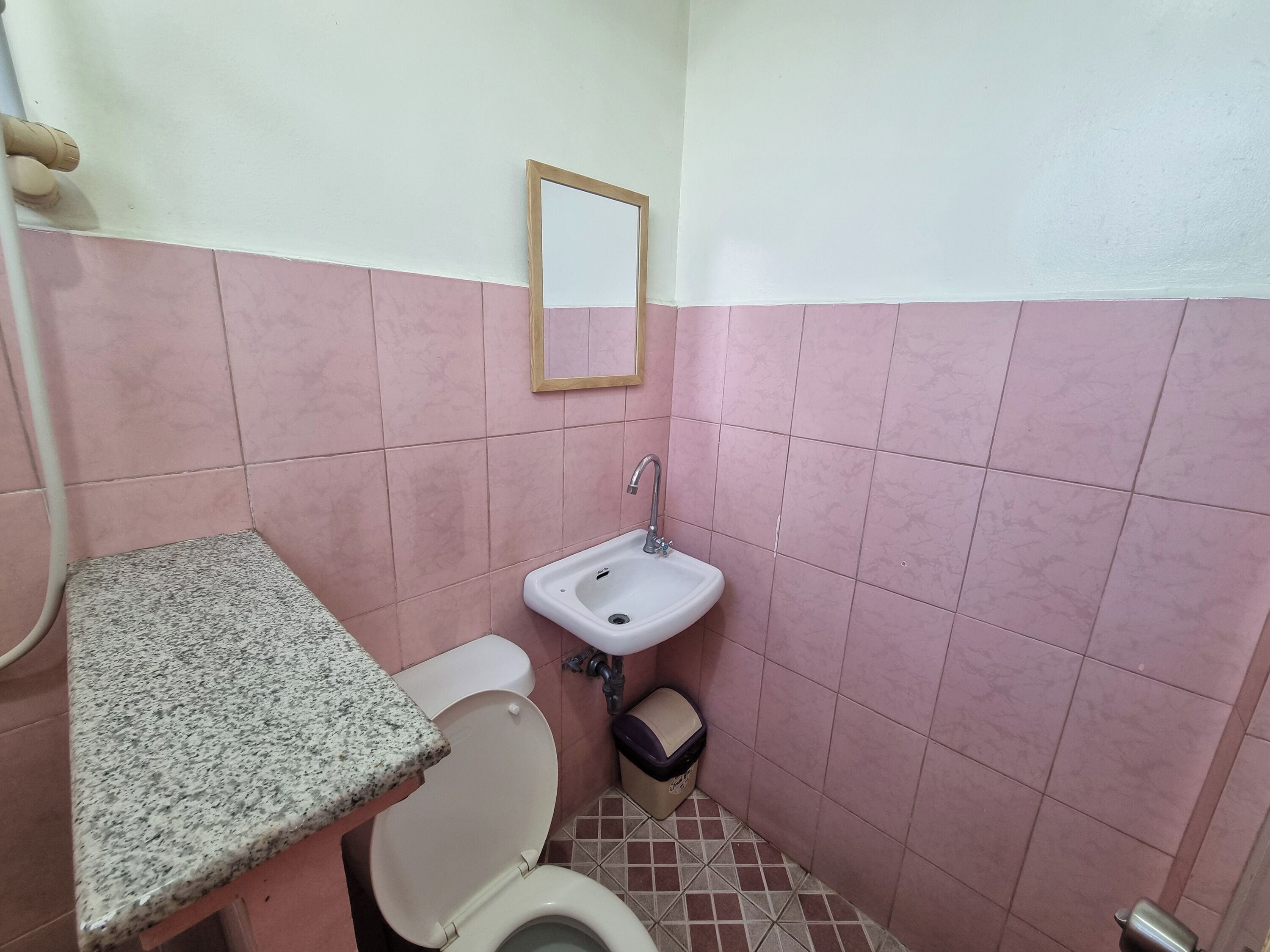 Un baño pequeño con inodoro, lavamanos y espejo.