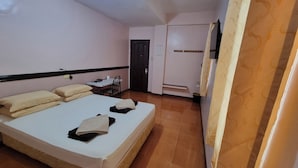 A hotel room with a bed, a desk, a chair, and a wardrobe. - Palm Woods Pensionne Home General Santos (General Santos)