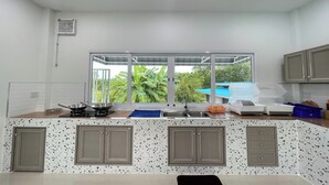 Une cuisine avec une fenêtre, des placards, un évier et une cuisinière.