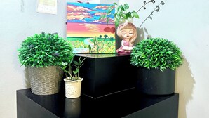 A black table with three potted plants and a painting. - Lazy Gibbon 1 Chiang Mai - Tha Phae Gate (Chiang Mai)