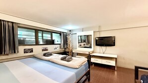 A bedroom with a bed, a TV, a desk, and a window. - Lazy Gibbon 1 Chiang Mai - Tha Phae Gate (Chiang Mai)