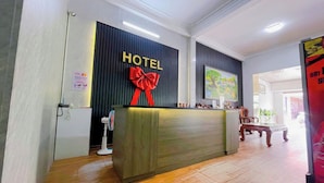 Ein Hotelrezeptionstresen mit einem 'HOTEL'-Schild und einer roten Schleife.