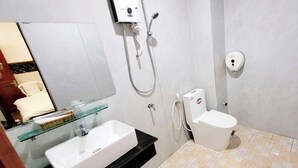 A bathroom with a white sink, glass shelf, toilet, and a shower unit. - Phuc Khang Airport Hotel (Ho Chi Minh City)