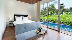 Une chambre avec un lit, des tables de chevet, une petite table avec une plante, et une vue sur une piscine et un espace verdoyant.
