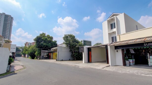 A street view with buildings, a sign for 'SM Hotel', and a storefront with a sign that reads 'SUR'. - Hotel O near Taman Sriwedari formerly In (Surakarta)