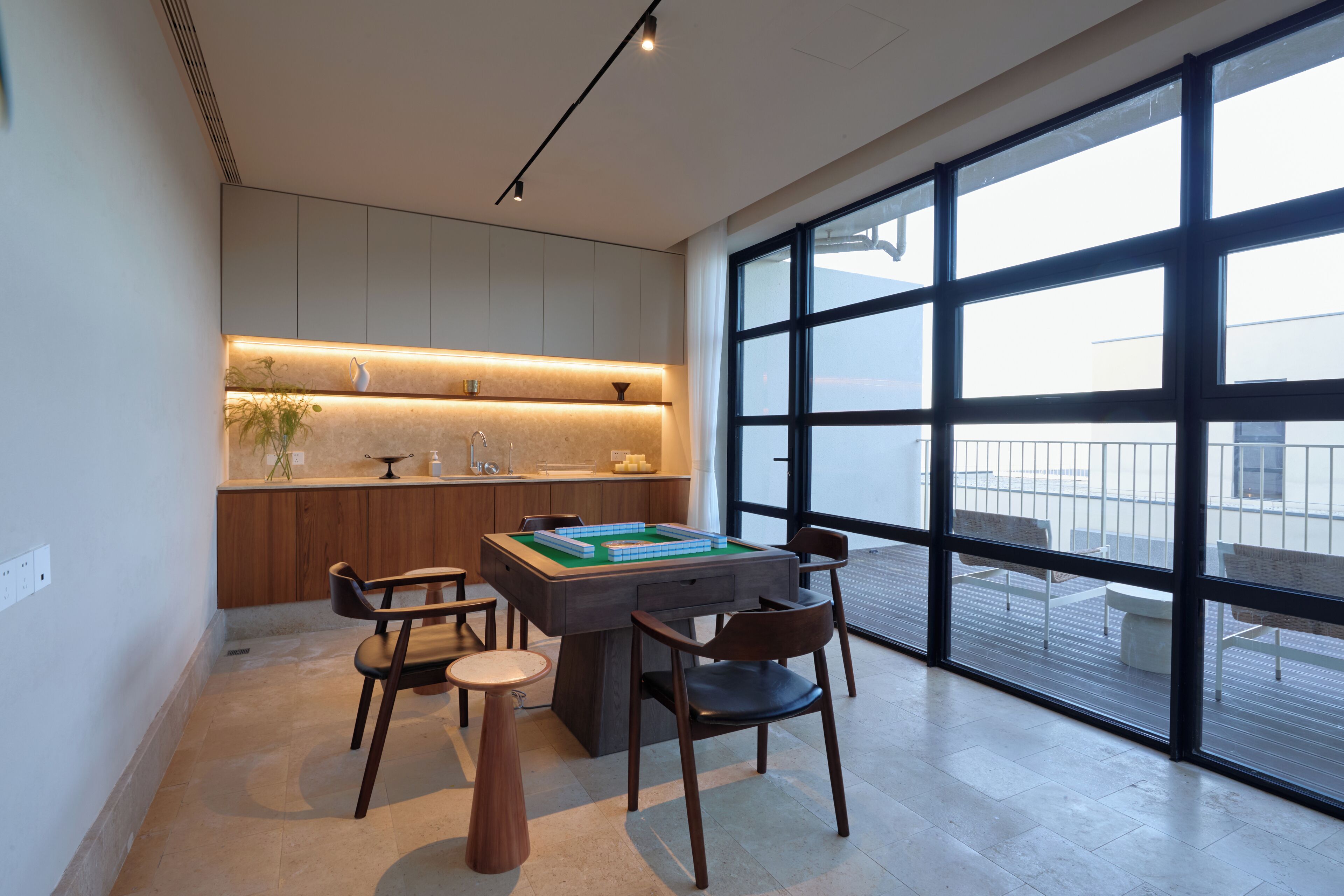 A modern kitchen with a dining area, large windows, and a view of the city.