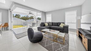 Una sala de estar moderna con un sofá modular, una mesa de centro y un televisor.